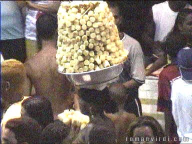 Food seller has goods expertly balanced on her head and doesn't seem to have any problems with the crowd!