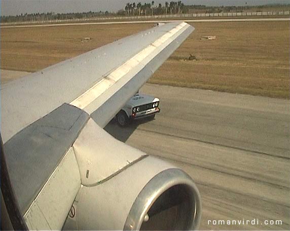 Security car driving along with the plane during takeoff at Havana Airport to make sure no Cubans escape the country!