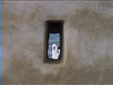 Peering through hole in Hammamet fort wall. The sea in in the background