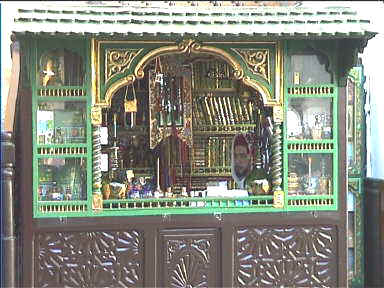 Shopkeeper using a mirror to peer out onto the from his small storefront (Tunis)