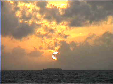 The setting sun over a neighbouring island