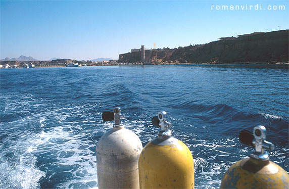 Setting off on a dive boat from Sharm el Sheikh harbour. You can see the tower-live elevator structure of the luxury hotel there (it used to be the Sheraton Residence, but has since changed hands). This picture was taken in 1996, when all dive boats left from here. Today, most boats conveniently leave directly from Naama Bay harbour, where most of the hotels are located