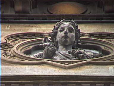 Figure peering down from a wonderful old house facade in Pisa